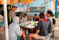 Personel Satlantas Polresta Sumenep memberikan edukasi keselamatan berlalu lintas sekaligus menyosialisasikan program Halo Kapolresta kepada masyarakat di kawasan Pelabuhan Kalianget, Jumat (31/7/2026).